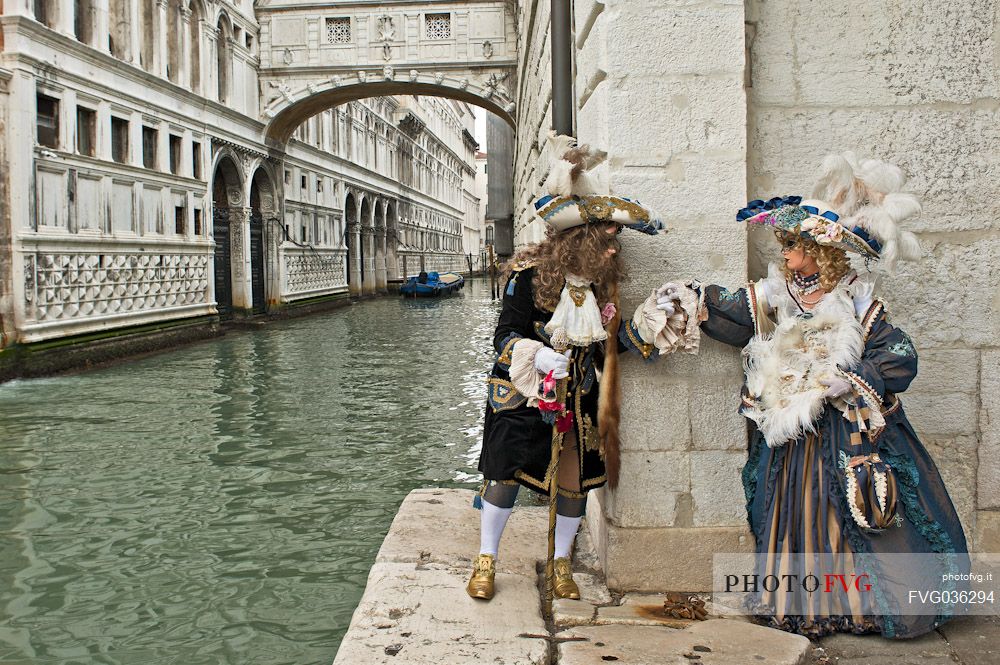 Beautiful couple of masks at bridge of Sighs during the carnival of Venice, Italy, Europe