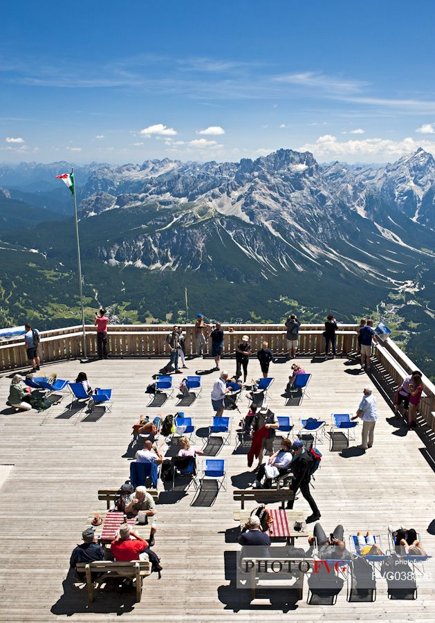 Tourists enjoy the view of the Dolomites and the Sorapiss group from the panoramic terrace of Cima Tofana peak, Cortina d'Ampezzo. Belluno, Italy.