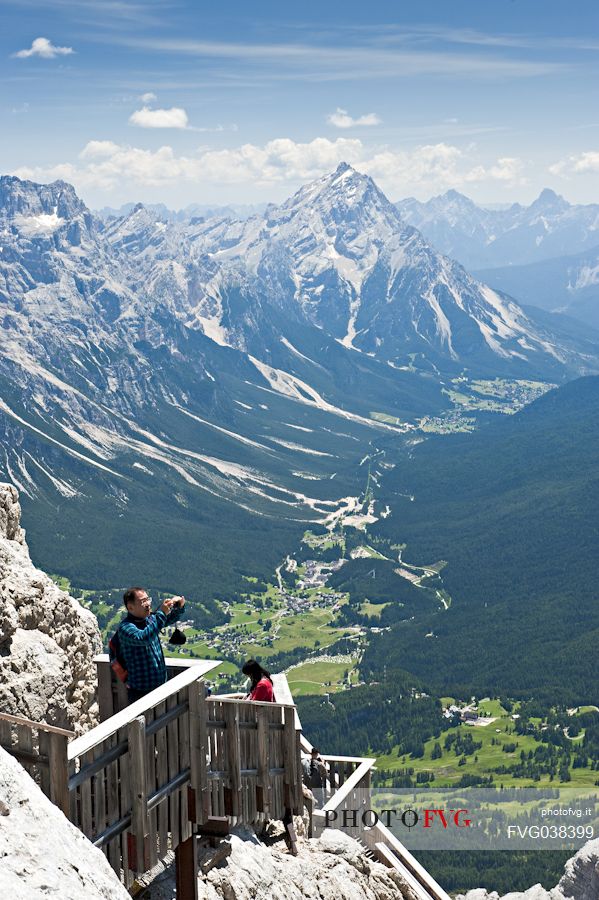 From the Cima Tofana a tourist photographs the Dolomites. Downstream the city of Cortina ad the Cadore valley, Belluno, Italy.