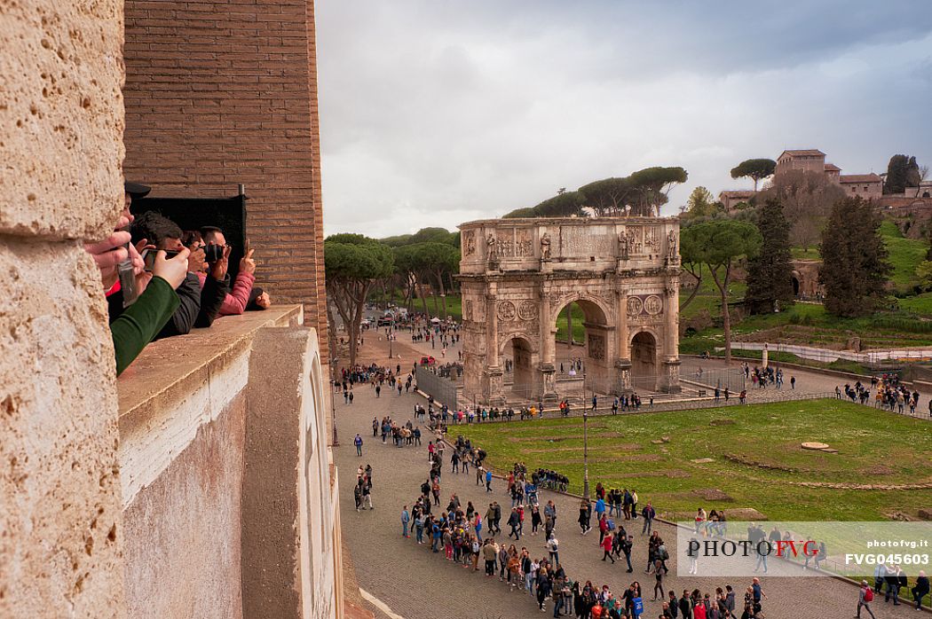 From the top of the Colosseum, tourists photograph the Arch of Titus or Arco di Tito, Roman Forum, Rome, Italy, Europe