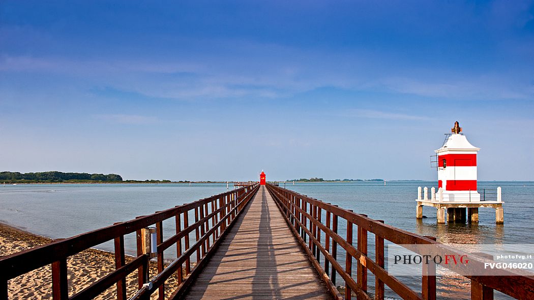 The pier of Punta Faro and the Faro Rosso lightouse in Lignano Sabbiadoro, Friuli Venezia Giulia, Italy, Europe