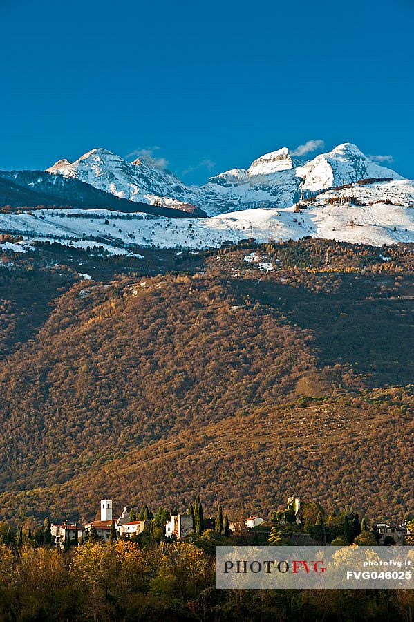 Characteristic village of Castello d'Aviano and in the background the snowy mountain group of Monte Cavallo, Pordenone, Friuli Venezia Giulia, Italy, Europe