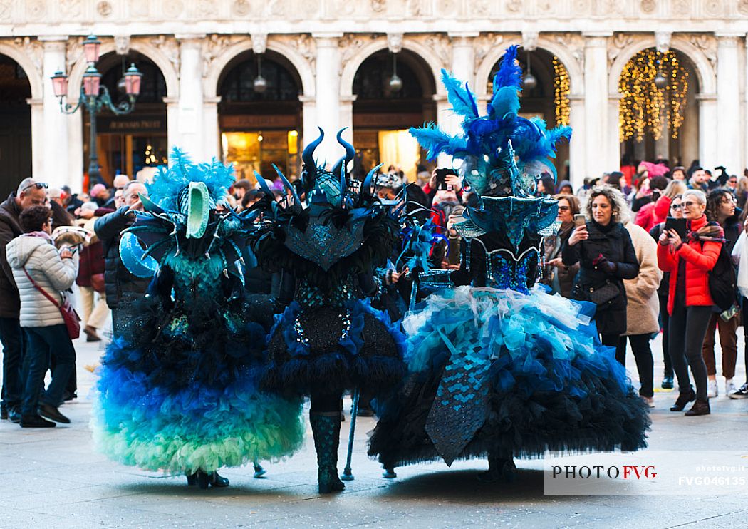 Tourists photograph carnival masks in San Marco square in Venice, Italy, Europe