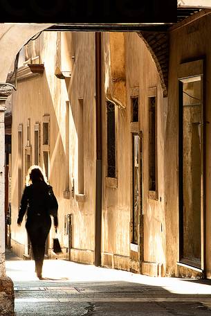 A woman walks in the historic center of Pordenone, Friuli Venezia Giulia, Italy, Europe