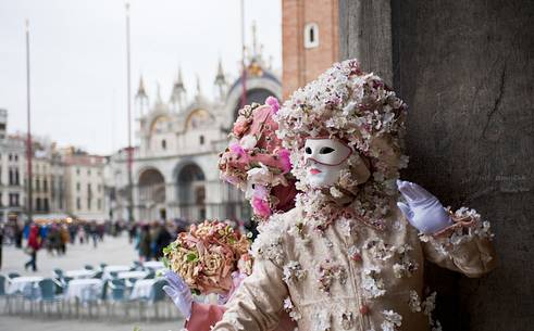 Masks in St. Mark's Square in Venice, in the background the Basilica of San Marco, Venice, Italy