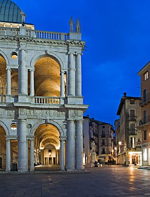 The Basilica Palladiana is a Renaissance building in the central Piazza dei Signori in Vicenza at twilight. Beside the statue of the architect Andrea Palladio, Vicenza, Italy, Europe