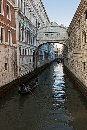 Tourists in a gondola admire the Bridge of Sighs for Ponte dei Sospiri, Venice. Italy.
