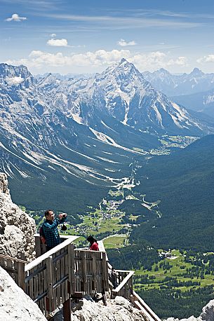 From the Cima Tofana a tourist photographs the Dolomites. Downstream the city of Cortina ad the Cadore valley, Belluno, Italy.