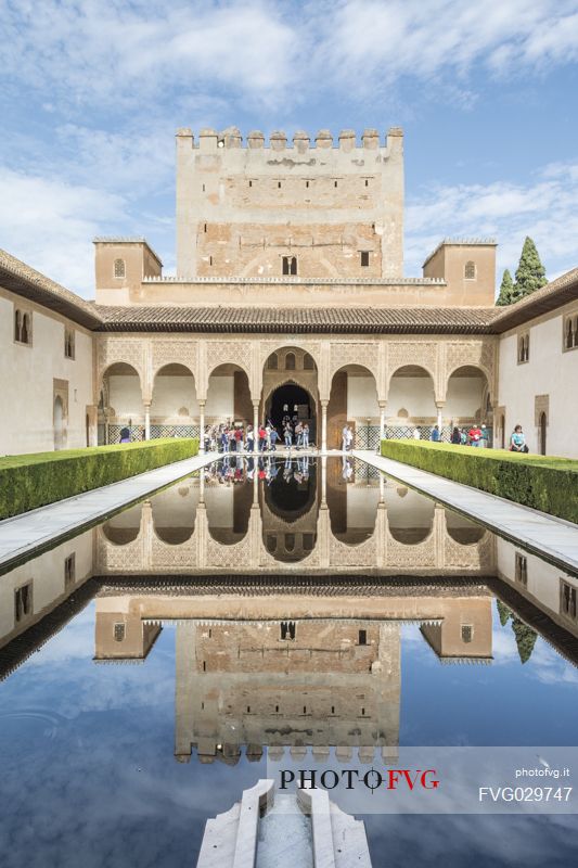 Comares palace reflects in the pond of Arrayanes Patio, part of Nazaries Palace, in the complex of the Alhambra, Granada, Spain