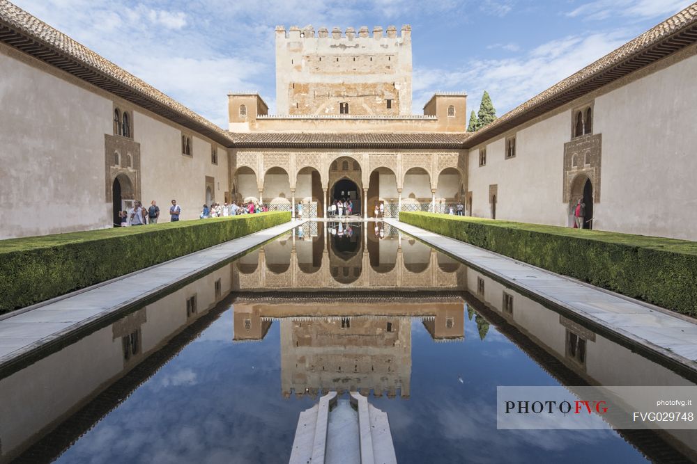 Comares palace reflects in the pond of Arrayanes Patio, part of Nazaries Palace, in the Alhambra complex, Granada, Spain