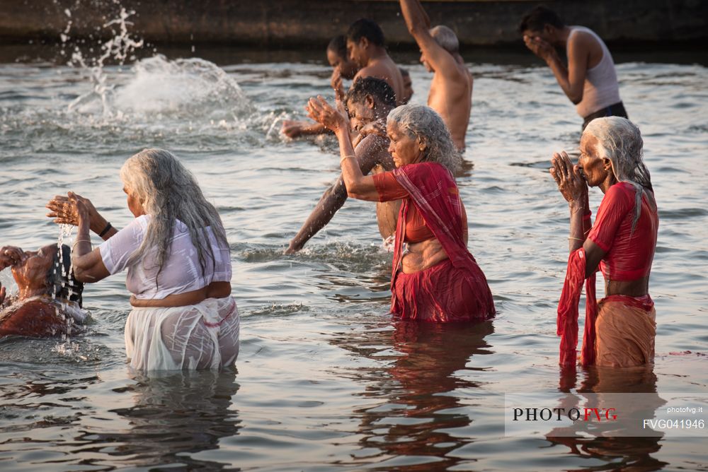 Indian Hindu pilgrims bathing in the Ganges river in Holy City of Varanasi, Benares, India