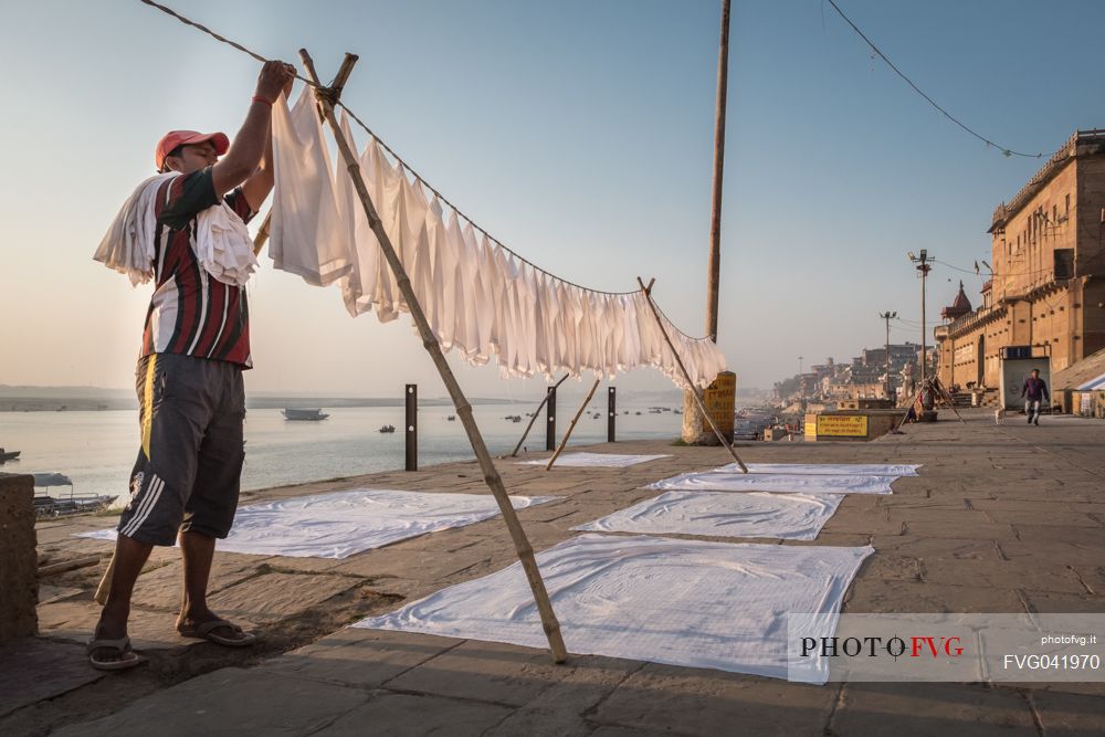 Man hanging out the laundry on the banks of the Ganges river in Varanasi, Uttar Pradesh,India