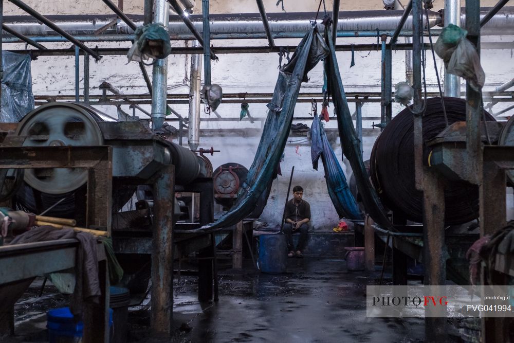 Worker in a textile factory in the commercial district of Pali, Rajasthan, India