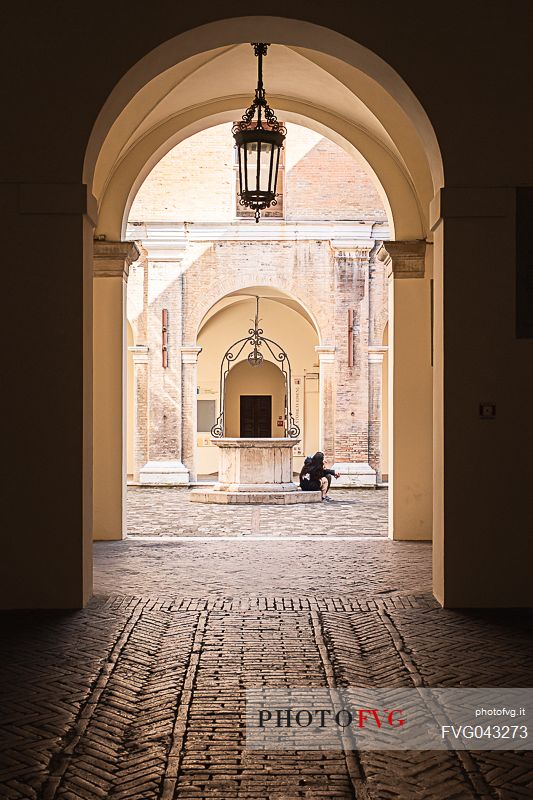 Main entrance of Gambalunga library in Rimini which opens up into a beautiful courtyard with a 17th century well at its centre, Rimini, Emilia Romagna, Italy, Europe