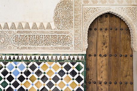 Detail of a door and wall decoration in the Arrayanes Patio, part of teh Nazaries Palace, in the Alhambra complex, Granada, Spain