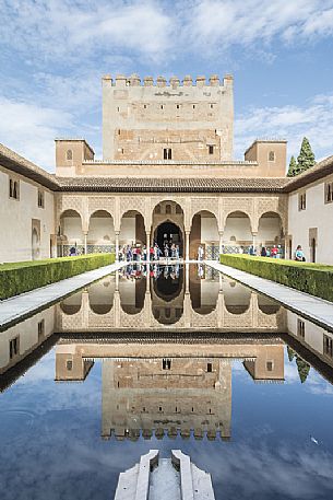 Comares palace reflects in the pond of Arrayanes Patio, part of Nazaries Palace, in the complex of the Alhambra, Granada, Spain