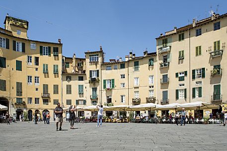 The picturesque Piazza Anfiteatro square in Lucca downtown, with its yellow houses and curved walls, Tuscany, Italy The picturesque Piazza Anfiteatro square in Lucca downtown, with its yellow houses and curved walls, Tuscany, Italy