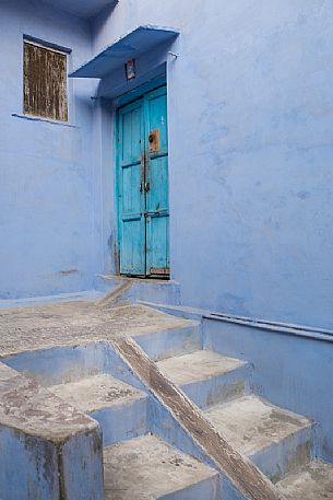 Detail of a street in Bundi with typical blue walls and colored door, Rajasthan, India
