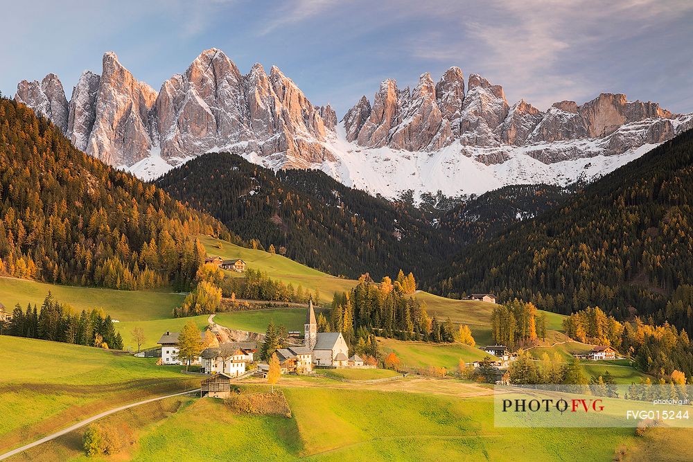 The beautiful frame of the Odle and the church of santa Maddalena illuminated by the last lights of the day in the Funes valley 