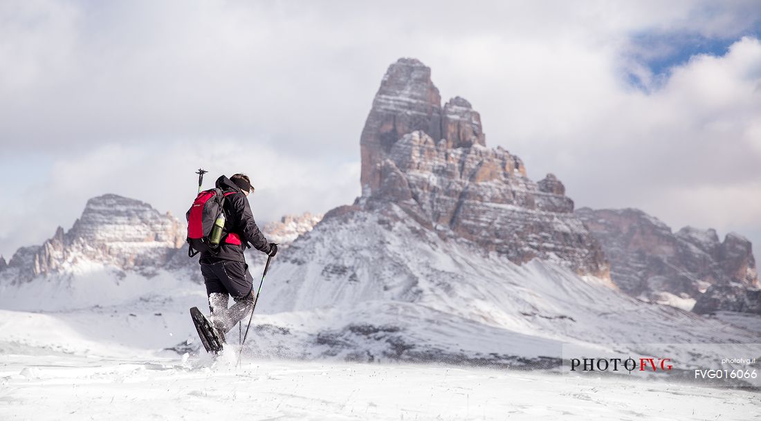 Snowshoeing on Piana Mount with the Tre cime di Lavaredo on background