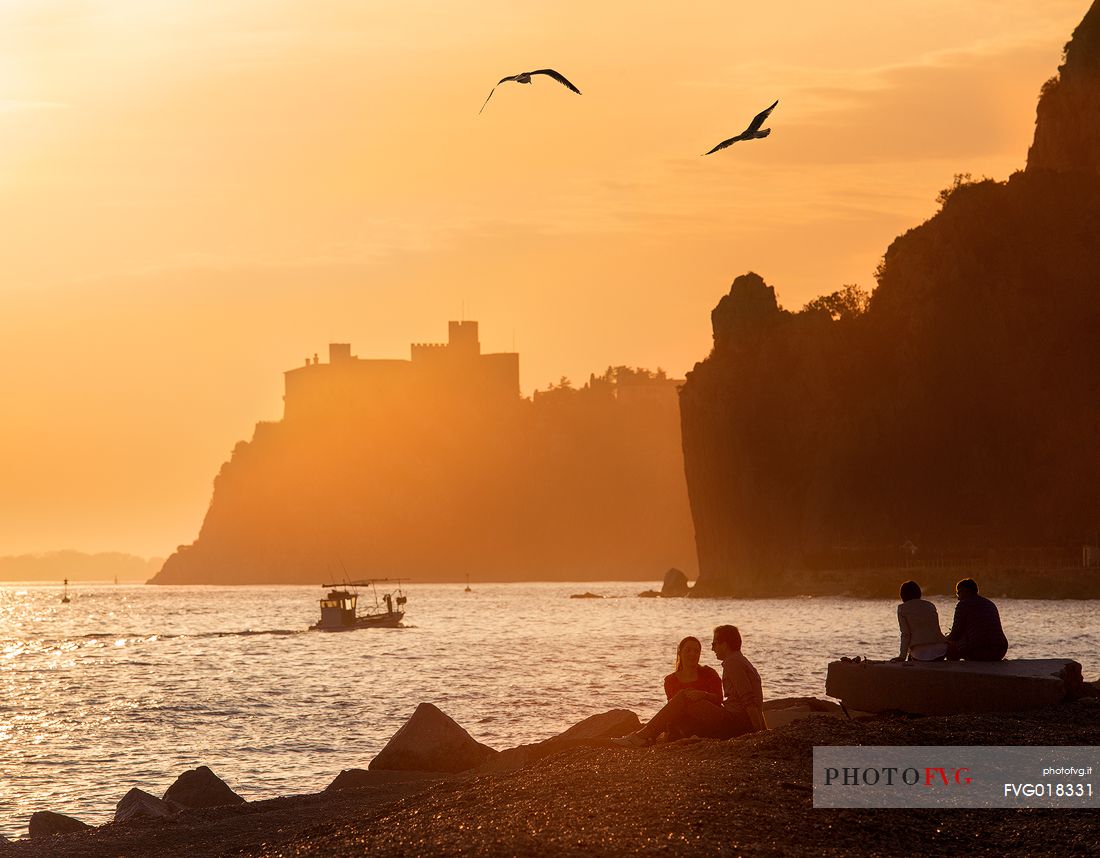 The Duino castle at sunset photographed from Porto Piccolo's beach in Sistiana