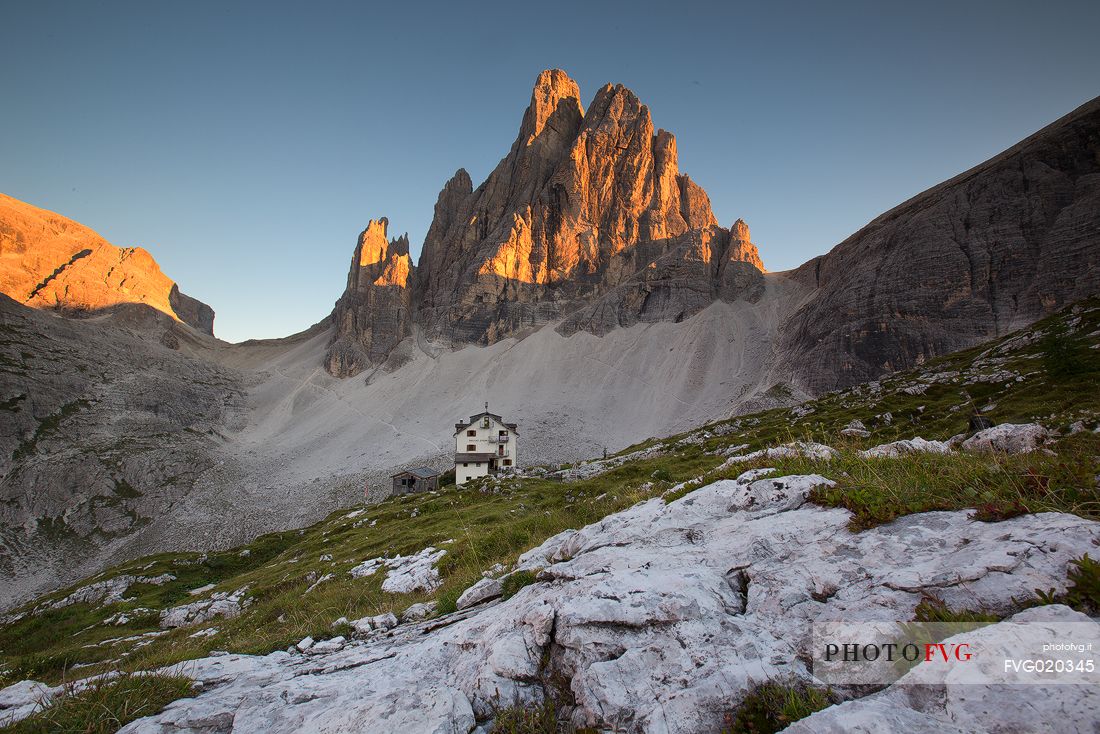 The alpine hut of Zsigmondy Comici with the Croda dei Toni on background lit by sunset, Sexten dolomites, Tre Cime natural park, South Tyrol, Italy, Europe