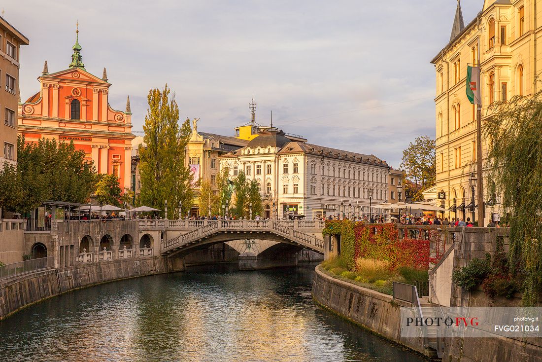 The characteristic Triple Bridge or Tromostovje bridge and in the background the Franciscan church and the palaces in the center of Lubiana, Slovenia, Europe
