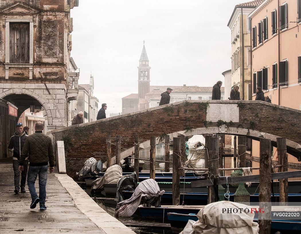 Fog over the Canal Vena, one of the most picturesque canals of Chioggia, in the background the church tower of St. James, Chioggia, venetian lagoon, Italy