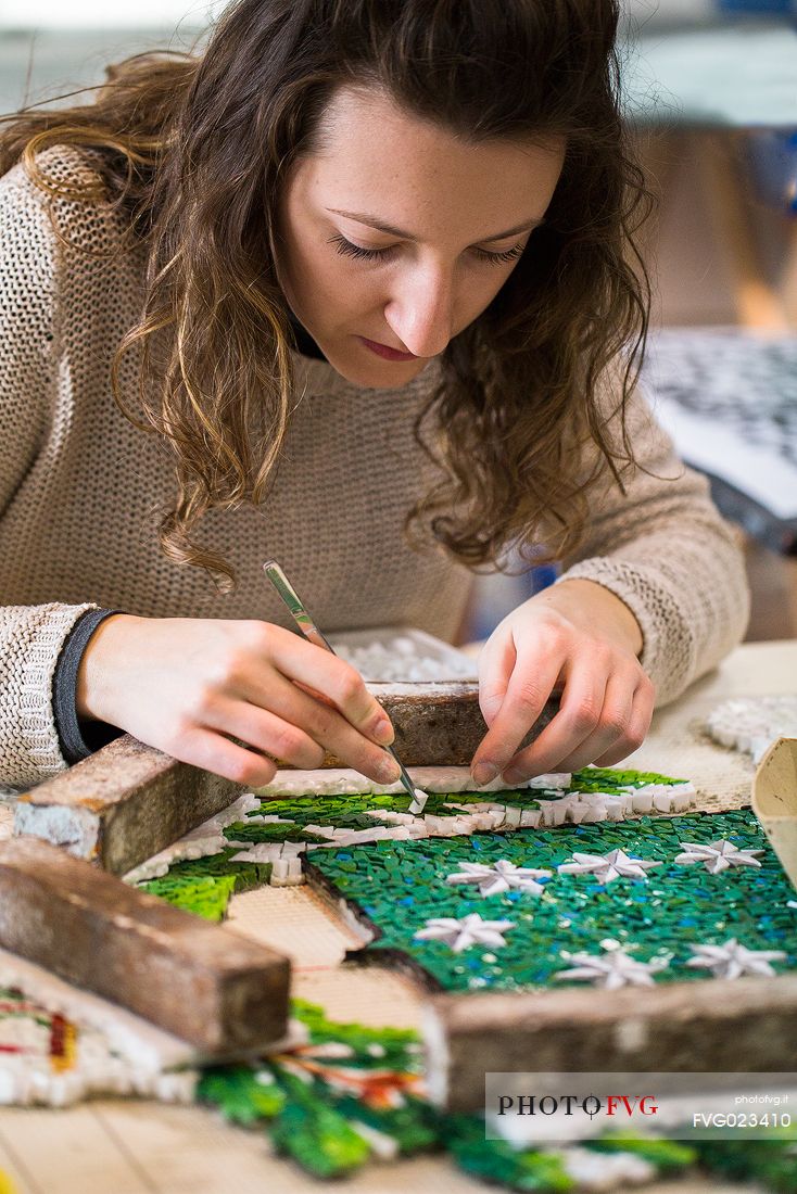 Young girl learns the art of mosaic in the oldest Mosaic School of Friuli , Italy