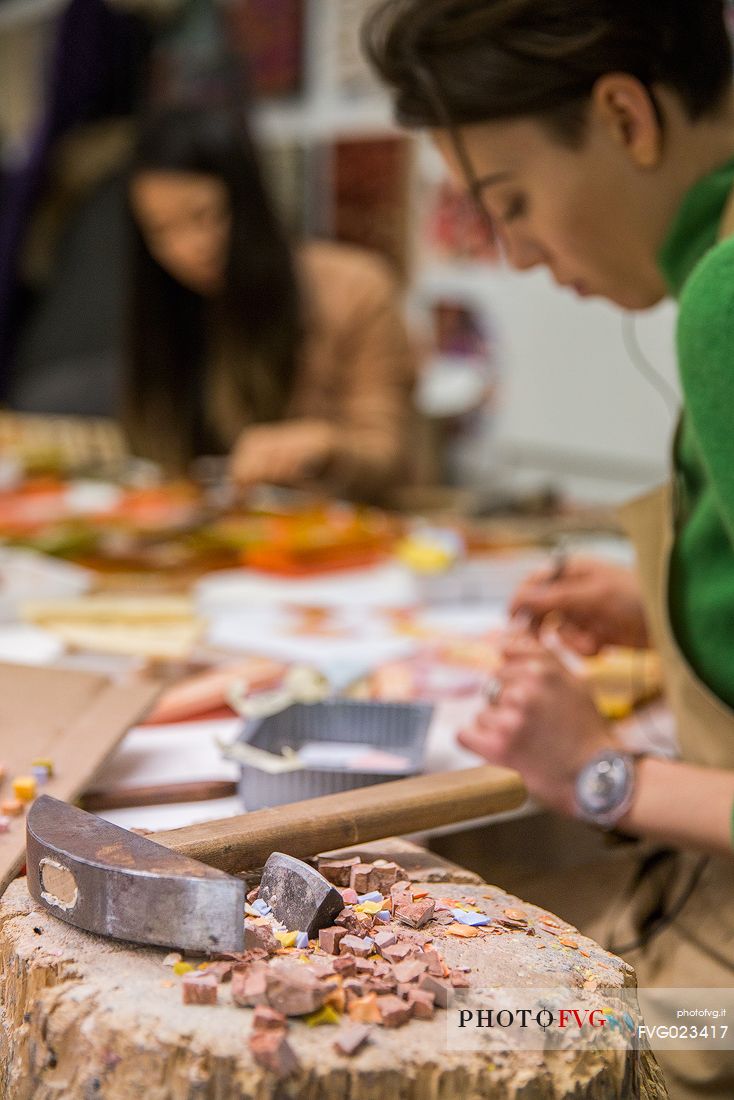 Young girl learns the art of mosaic in the oldest Mosaic School of Friuli , Italy