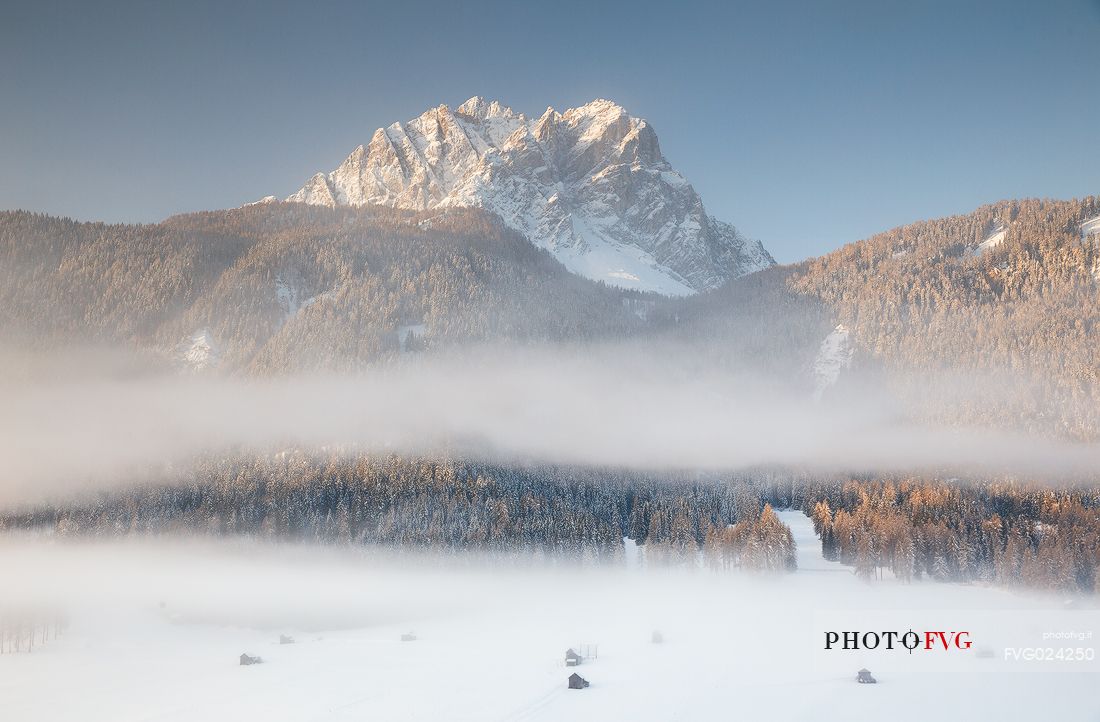 The barns of Sesto under the morning fog and the Cima di Sesto on background, Sesto, dolomites, Italy