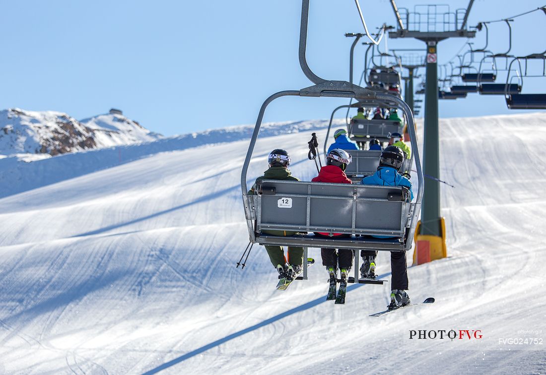 Group of skiers on the chairlift to Elmo Mount, Sesto, Pusteria valley, Italy