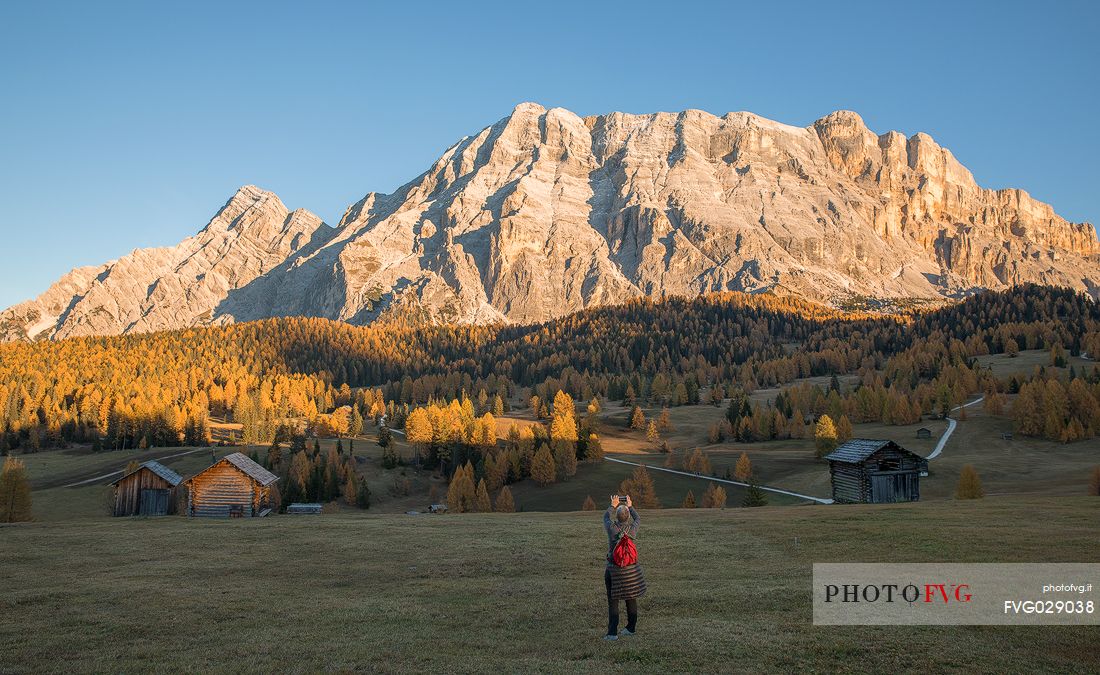 Tourist photographs the autumnal Armentara meadows in the Fanes Senes Braies natural park, Val Badia, Trentino Alto Adige, Italy