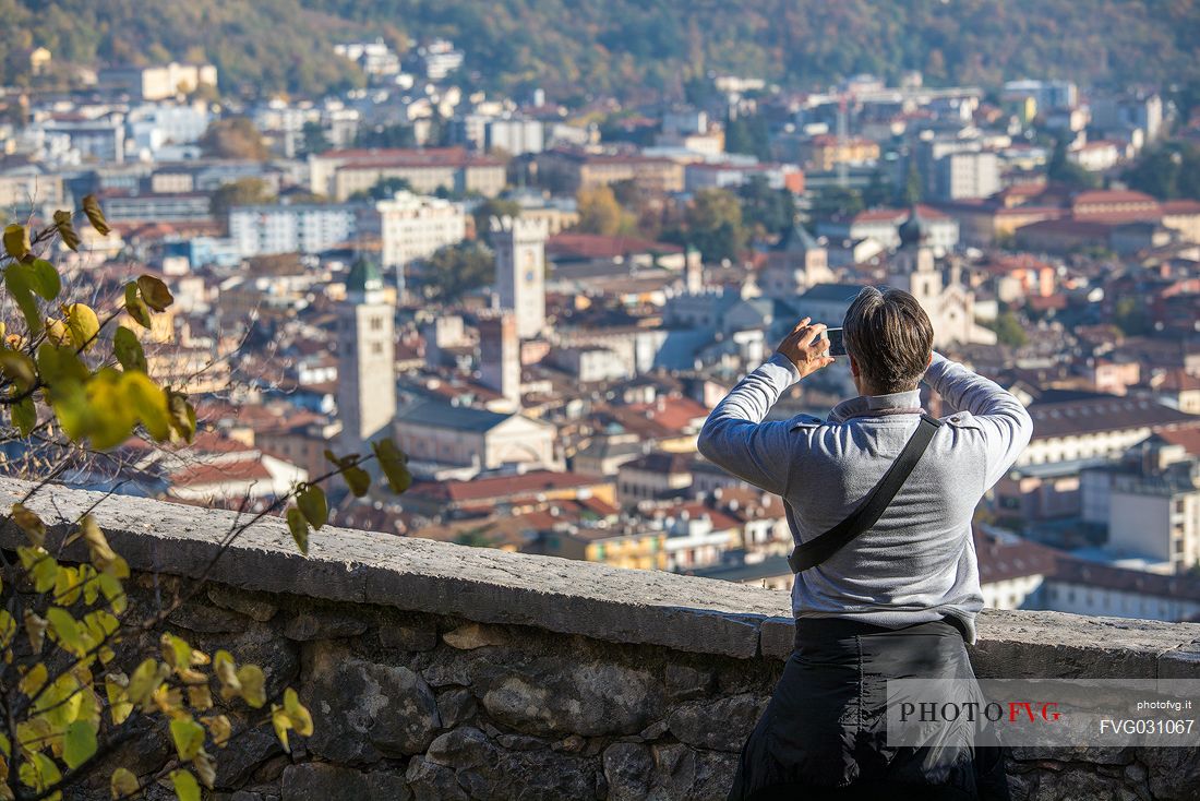 Tourist photographs the city of Trento from Doss Trento, Trento, Trentino Alto Adige, Italy

