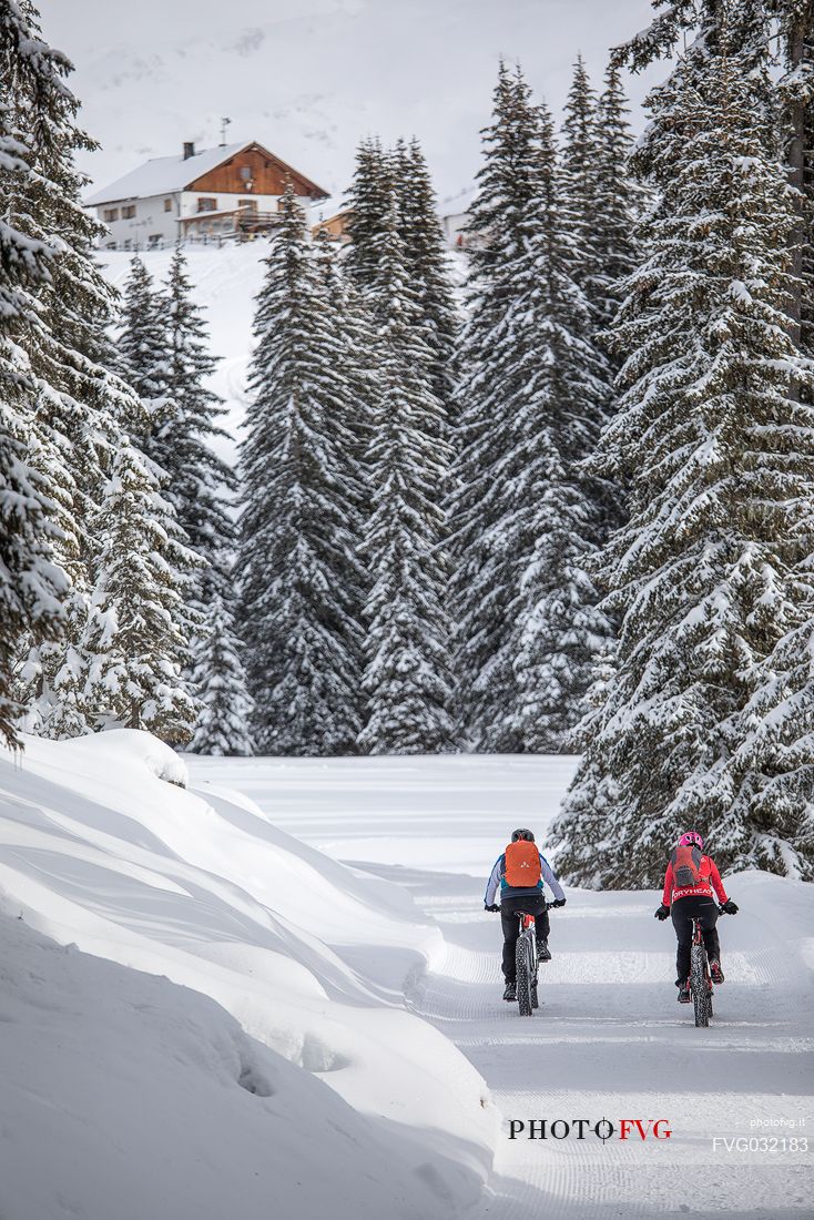 Two bikers along the path leading to the Nemes refuge in the backgroud, Sesto, Pusteria valley, Trentino Alto Adige, Italy, Europe