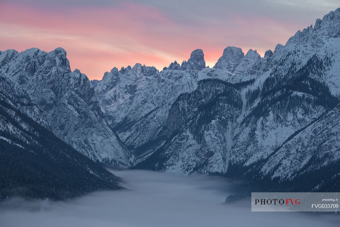 The peaks above the village of Dobbiaco covered by low clouds, in the background  Cristallo and Piz Popena mount, Pusteria valley, dolomites, Trentino Alto Adige, Italy, Europe