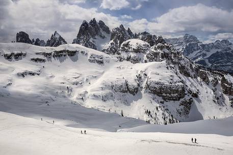 Hikers along the path to Auronzo Refuge, in the background the mountain group of Cadini di Misurina Hikers along the path to Auronzo Refuge, in the background the mountain group of Cadini di Misurina