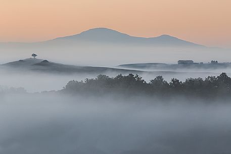 The fog of an autumn sunrise over the hills of the Val D'Orcia