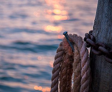 Detail of a venetian pier in the lagoon with rope rolled 