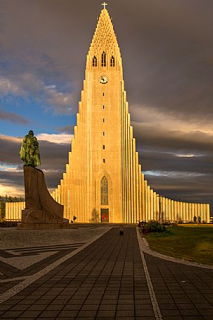 The white church of Hallgrmskirkja ,adjacent to the ancient center of Reykjavik ; on the left the statue of the viking Lefur Eriksson