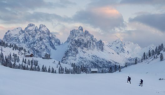 Snowshoeing at sunset to Prato Piazza with the group of Cadini on background Snowshoeing at sunset to Prato Piazza with the group of Cadini on background