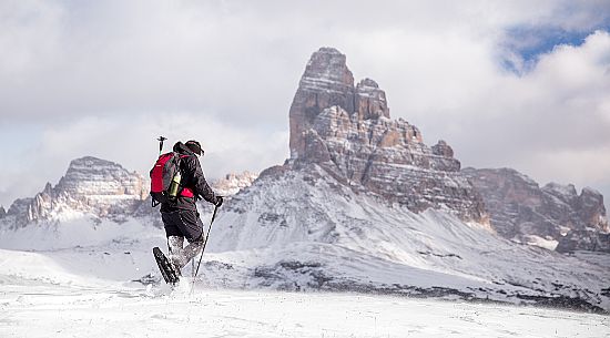 Snowshoeing on Piana Mount with the Tre cime di Lavaredo on background