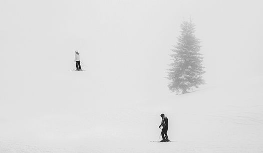 Skiers in the fog on the slopes of Croda Rossa