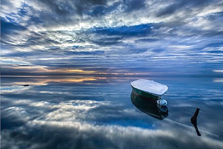 Reflections of an overcast summer sunrise on the lagoon of Grado Reflections of an overcast summer sunrise on the lagoon of Grado