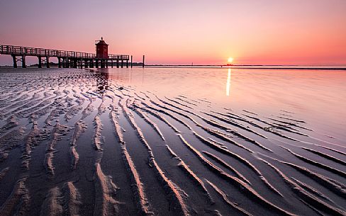 The old lighthouse in Lignano Sabbiadoro during a summer sunrise