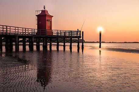 The old lighthouse in Lignano Sabbiadoro during a summer sunrise