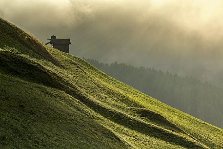 Dawn light rays on meadows of Sesto in Pustertal