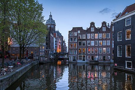 View on canal and old houses in historic center of Amsterdam, with the Basilica of St. Nicholas on Background