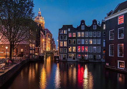 View on canal and old houses in historic center of Amsterdam, with the Basilica of St. Nicholas on Background