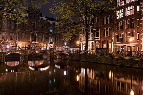 Amsterdam canal located in the red light district illuminated at night